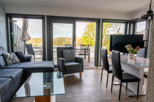 a living room with a couch and a table and chairs at Haus Windhook in Dierhagen