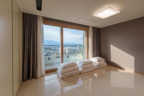 a room with a large window with white towels at Hotel The Blue Terra in Sokcho
