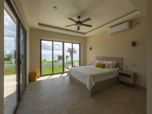 - une chambre avec un lit et un ventilateur de plafond dans l'établissement Arrue's Coastal Escape, à Pedasí Town