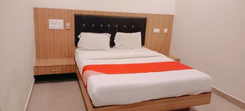 a bedroom with a large bed with a wooden headboard at HOTEL A.K.INTERNATIONAL INN in Ullāl