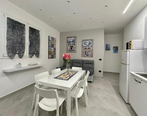 a kitchen and dining room with a white table and chairs at Giù dal Nonno in Carini