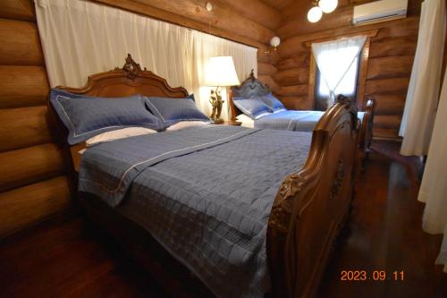 宮古島にあるペンション　プルシャンブルーのログキャビン内のベッドルーム1室(ベッド2台付)