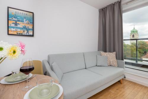 a living room with a couch and a table at Bright & Trendy Gdańsk Apartment with Balcony by Renters in Gdańsk