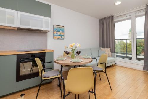 a kitchen and dining room with a table and chairs at Bright & Trendy Gdańsk Apartment with Balcony by Renters in Gdańsk