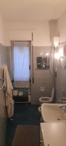 a bathroom with a toilet and a sink and a window at Stanza con vista P. Principe in Genova