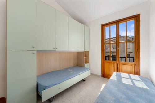 Schlafzimmer mit einem Bett, Schränken und einem Fenster in der Unterkunft San Pietro's House in Villa San Pietro