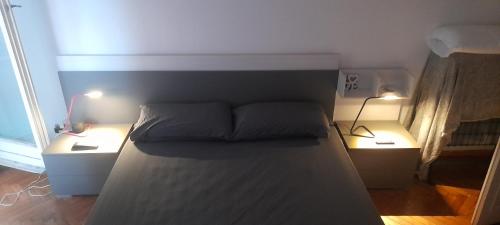 uma cama num quarto com duas lâmpadas em Stanza con vista P. Principe em Gênova