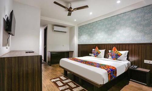 a bedroom with a large bed and a ceiling fan at FabExpress RG Stay in New Delhi