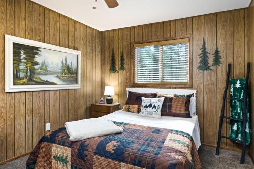 - une chambre avec un lit et une photo sur le mur dans l'établissement Beat The Heat, Book Now! Rogue Bear Cabin, à Williams