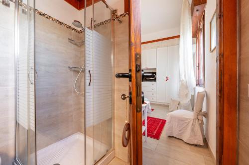 y baño con ducha y puerta de cristal. en Villa Rita, en Flumini di Quartu