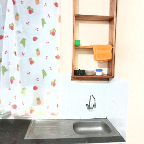 ein Waschbecken im Bad mit einem Apfelduschvorhang in der Unterkunft Miguel's haven, Homely vibes! in Kakamega