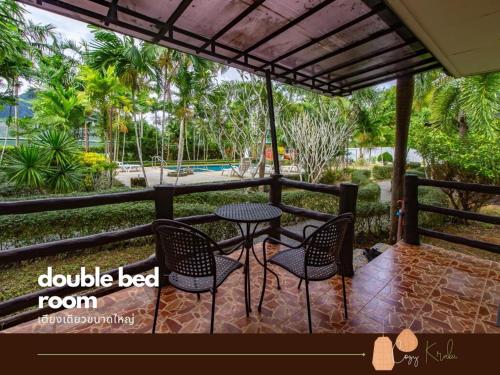 a patio with a table and chairs and a pool at Cozy Saithai Krabi in Krabi