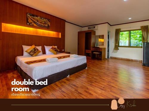 a bedroom with a large bed and a wooden floor at Cozy Saithai Krabi in Krabi