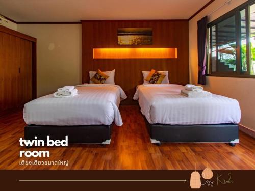 a bedroom with two beds with white sheets at Cozy Saithai Krabi in Krabi