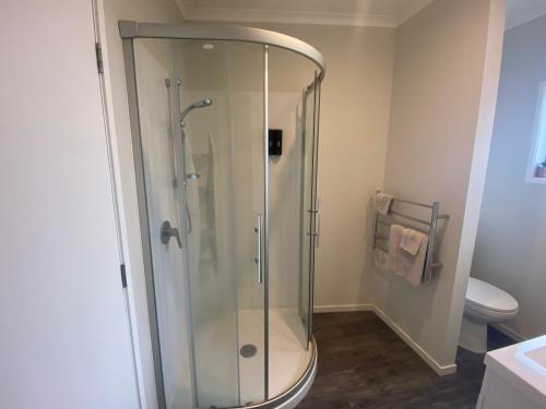 a glass shower in a bathroom with a toilet at Hamilton Hospital Retreat - 2 Bedroom Townhouse Modern Warm Quiet in Hamilton