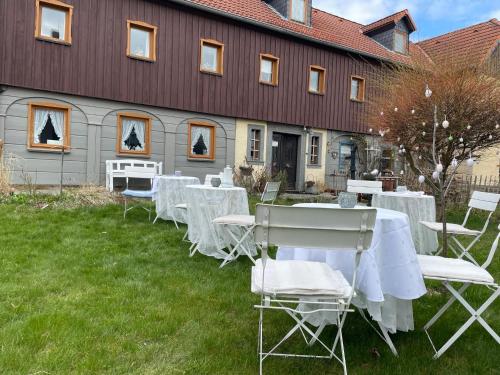 a group of tables and chairs in front of a building at Pension Grandel in Kottmar