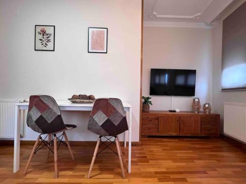 2 sillas en una sala de estar con mesa y TV en Apartamento Cantabrico vistas a la Ría deRibadeo, en Ribadeo