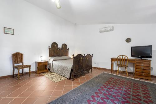 una camera con letto, TV e sedie di Maria Maddalena 3 - for families a Iglesias