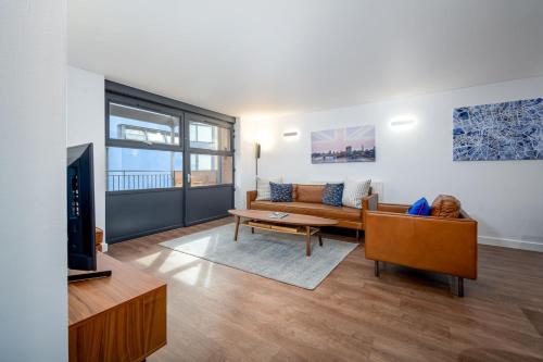 a living room with a couch and a tv at Modern & Spacious 2 Bedroom in Central London in London