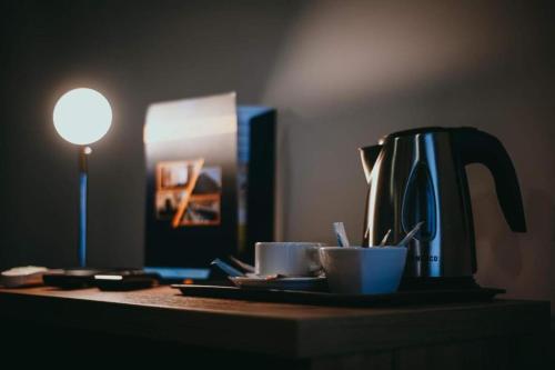 una cafetera y dos tazas en una mesa en S7 Hotel en Kielce