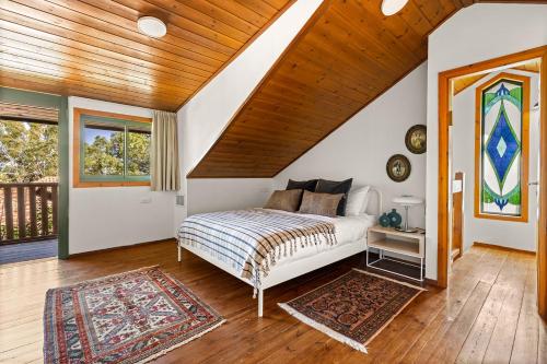 ロシュ・ピナにあるTHE HOUSE ROSH PINA - 2BRM WITH POOlの木製の天井が特徴のベッドルーム1室(ベッド1台付)