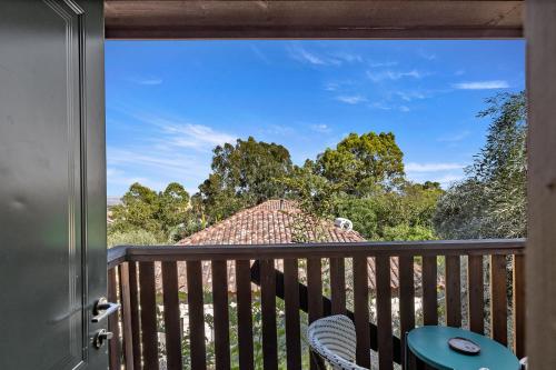 a room with a balcony with a view of a house at THE HOUSE ROSH PINA - 2BRM WITH POOl in Rosh Pinna