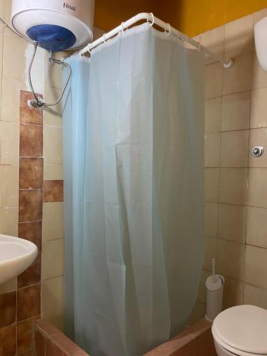 a bathroom with a shower curtain and a toilet at Hostal garbatella in Rome