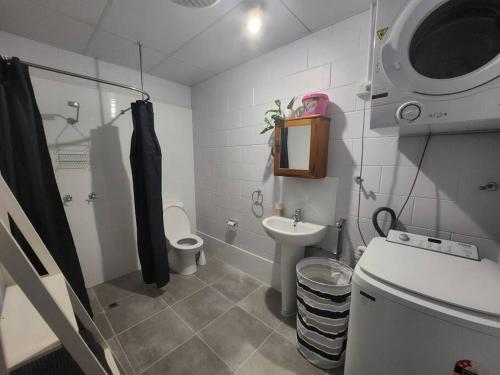 a bathroom with a toilet and a sink and a shower at Central Comfy Holiday Unit in Cooktown