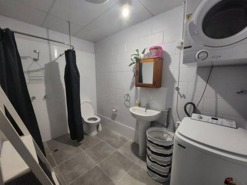 a bathroom with a toilet and a sink and a shower at Central Comfy Holiday Unit in Cooktown