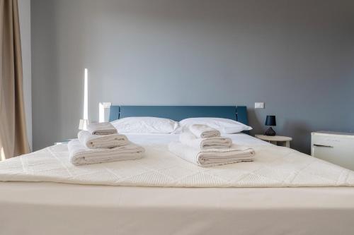 a white bed with towels on top of it at Serafini Rooms in Noto