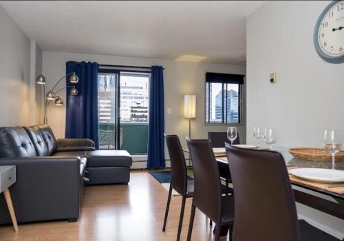 a living room with a couch and a table with chairs at Cozy apartment with amazing view in Calgary