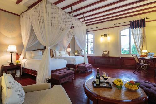 1 dormitorio con 1 cama con dosel en The Luang Say Residence, en Luang Prabang