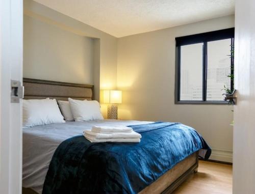 a bedroom with a bed with towels on it at Cozy apartment with amazing view in Calgary