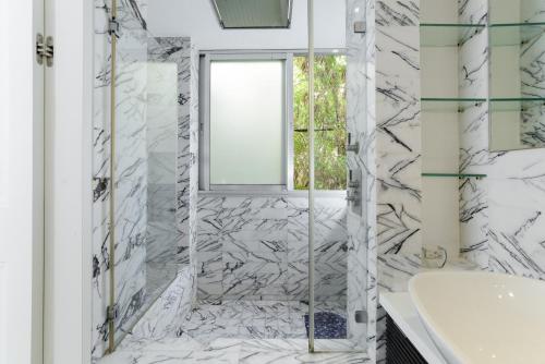a bathroom with white marble walls and a window at Luxury Chefs Apartment Near The Sea in Tel Aviv