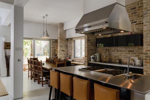 an open kitchen with a counter and a dining room at Luxury Chefs Apartment Near The Sea in Tel Aviv