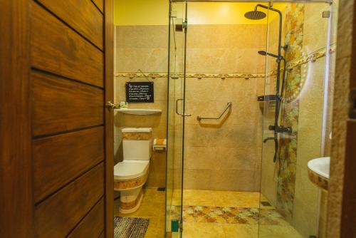 ein Badezimmer mit Toilette und Glasdusche in der Unterkunft La Casa Tagaytay in Tagaytay