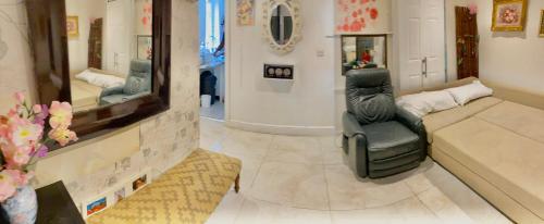 a living room with a chair and a mirror at 5 bedroom house in Hendon