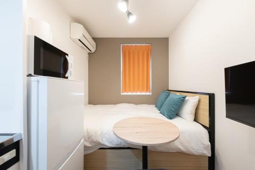 a small bedroom with a bed and a table at Verde Ikebukuro in Tokyo