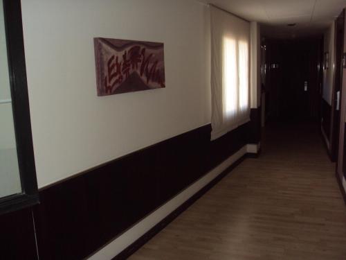 a hallway of an office with a painting on the wall at Hotel Puerta de Ocaña in Ocaña