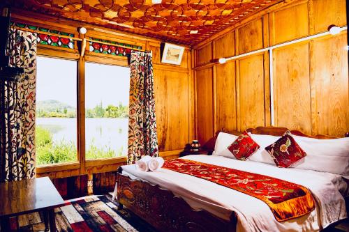 a bedroom with a bed and a large window at Golden Flower Heritage Houseboat in Srinagar