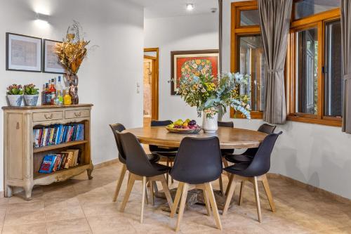a dining room with a wooden table and chairs at THE HOUSE ROSH PINA - 3BRM WITH POOl in Rosh Pinna