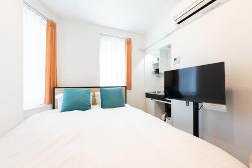 a bedroom with a bed and a flat screen tv at Verde Ikebukuro in Tokyo