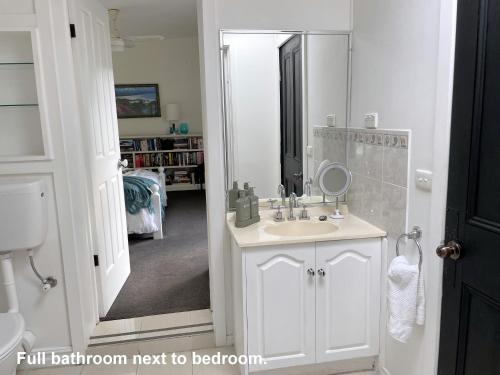 La salle de bains est pourvue d'un lavabo et d'un miroir. dans l'établissement Bayview Studio, à Inverloch