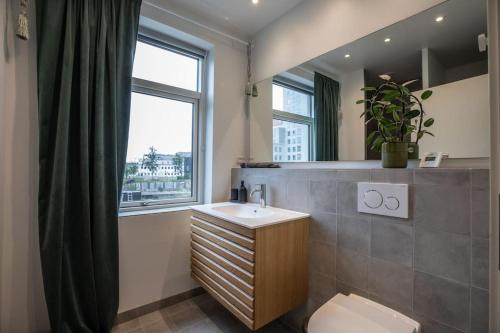 een badkamer met een wastafel, een toilet en een raam bij Stunning 3BR Near Beach & Metro in Kopenhagen
