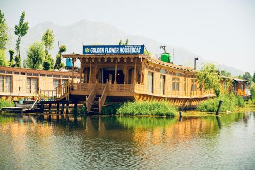 a large wooden building on the side of a river at Golden Flower Heritage Houseboat in Srinagar