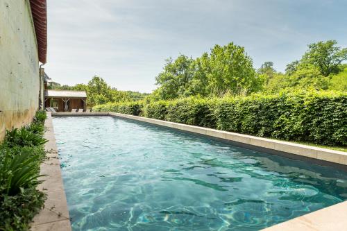 - une piscine d'eau bleue dans la cour dans l'établissement Gîte des Ecuries d'Hodebert, à Saint-Paterne-Racan