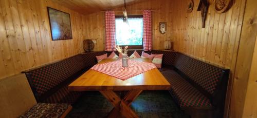 una sala da pranzo con tavolo in legno e cabine rosse di Würzburger Haus a Geroda