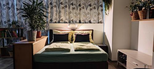 - une chambre avec un lit doté d'une tête de lit et de plantes dans l'établissement Ferienzimmer Seepark, à Vienne