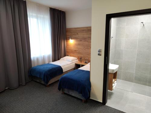 a hotel room with two beds and a shower at S7 Hotel in Kielce