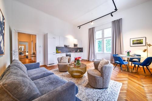 een woonkamer met een bank, stoelen en een tafel bij Smile Apartments am Stadtpark in Krems an der Donau